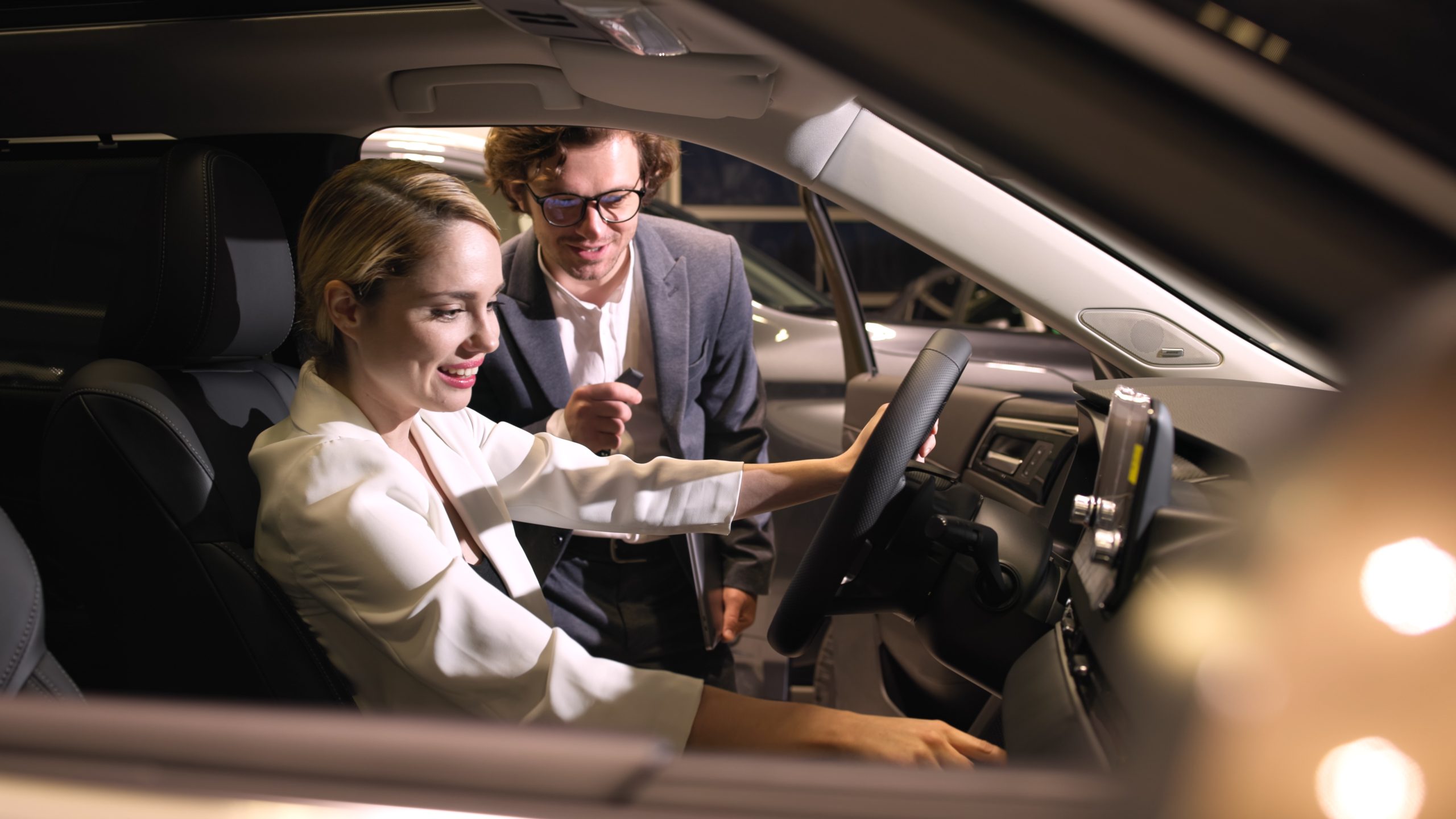 In a modern car showroom, a buyer inspects an elegant car before purchasing. This shot conveys the atmosphere of comfort and technology that appeals to modern car enthusiasts.